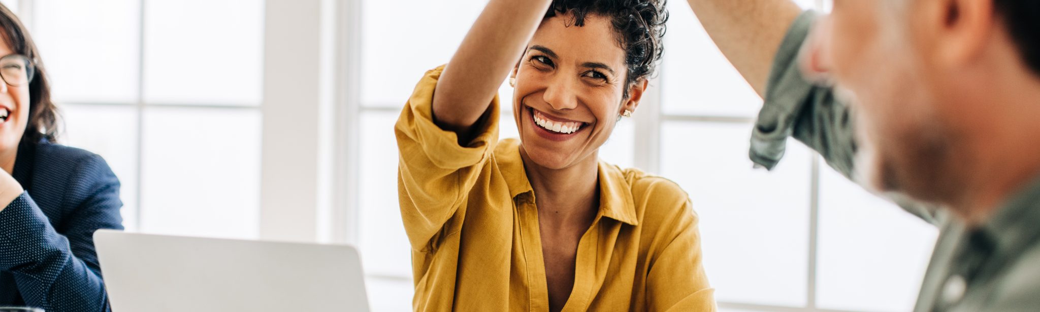 Business people celebrating success in an office. Happy business professionals doing a high five during a meeting. Teamwork and goal achievement.